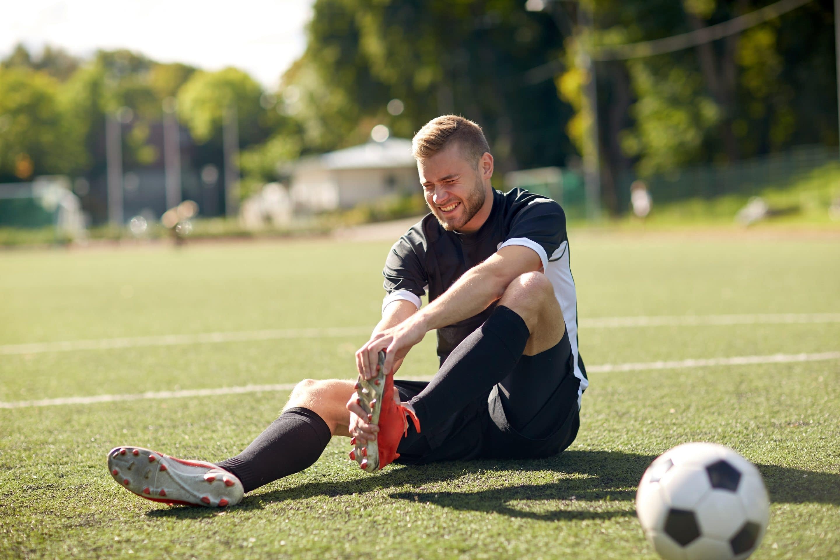 injured soccer player with ball on football field