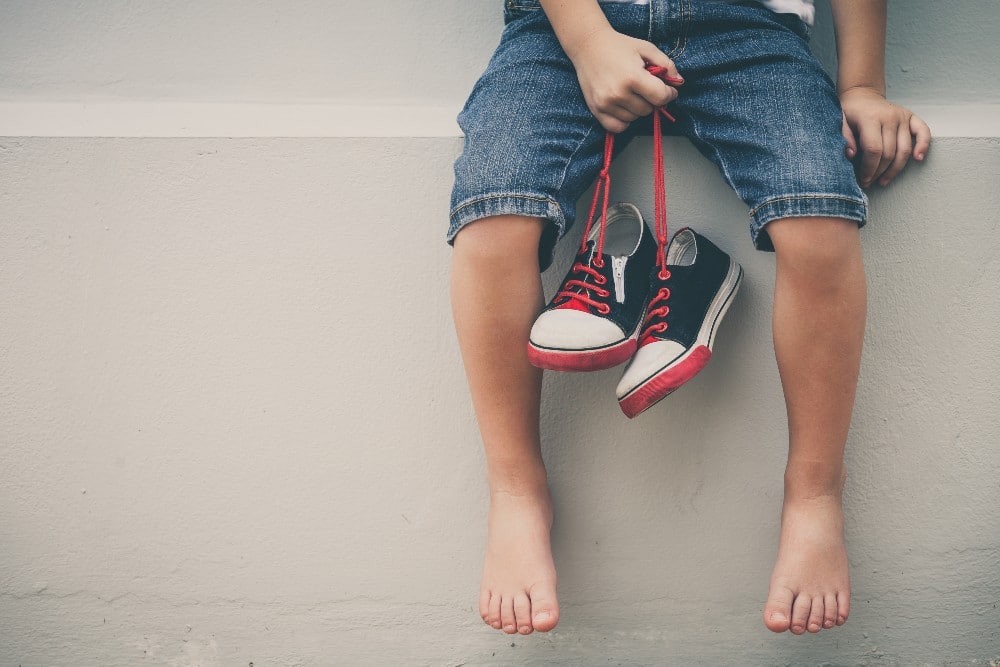 child holding shoes