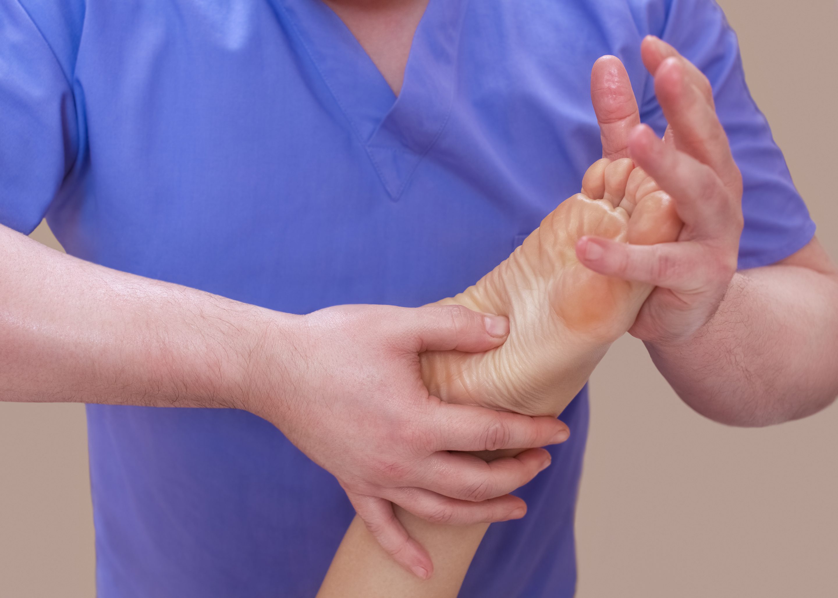 Doctor evaluating foot for plantar fasciitis and heel pain