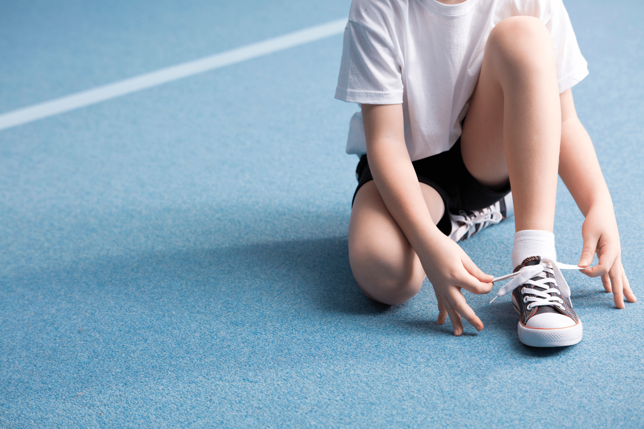 Kid tying shoe